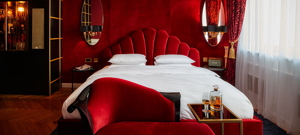 Bellevue Room: Rotes Kingsize Bett mit Sofa und Beistelltisch