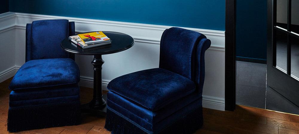 Maison Suite: blue velvet armchair, glass door to the bathroom