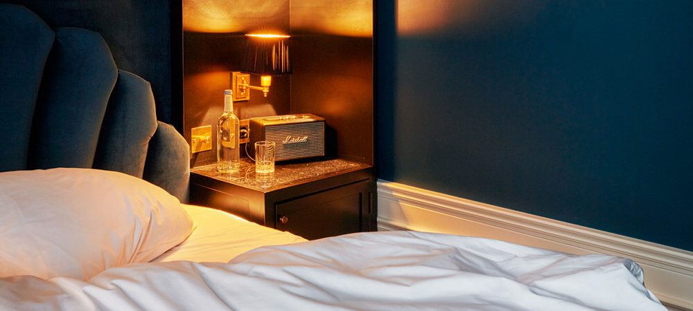 Petite Room: Dunkelblaues Zimmer, Samtbett, Nachttisch mit gemütlichem Licht