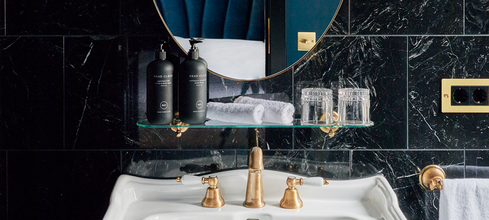 Petite Room: Retro Sink with golden fittings in a black marble bathroom