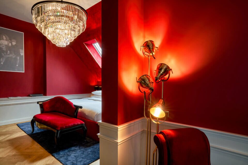 Terrace Suite: red velvet couch and armchairs and a warm light lamp
